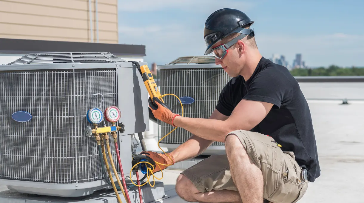 Technician servicing rooftop HVAC units with diagnostic tools